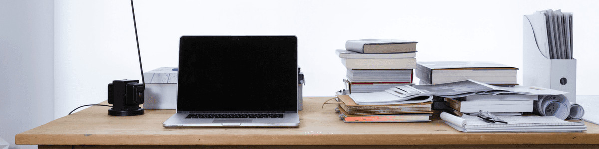 A desk, with a laptop and books